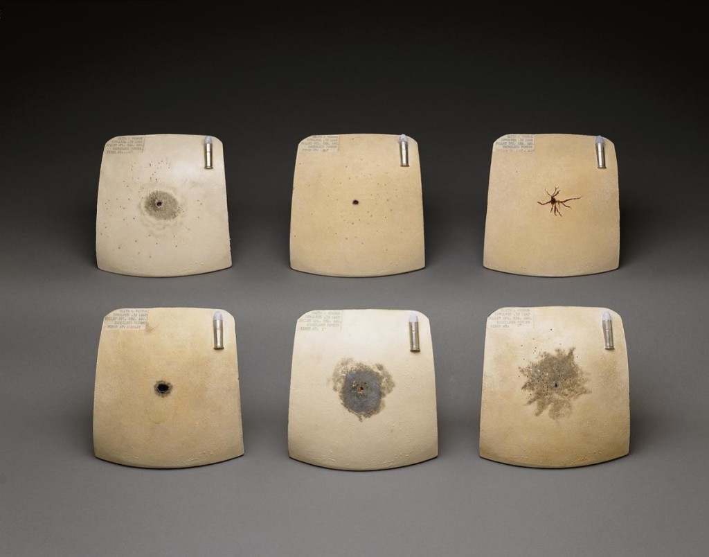Gunshot patterns on six ceramic chest plates.