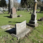 Broken marble tablet and marble monument foreground, red and grey granite background. Photo by CS Thomson.